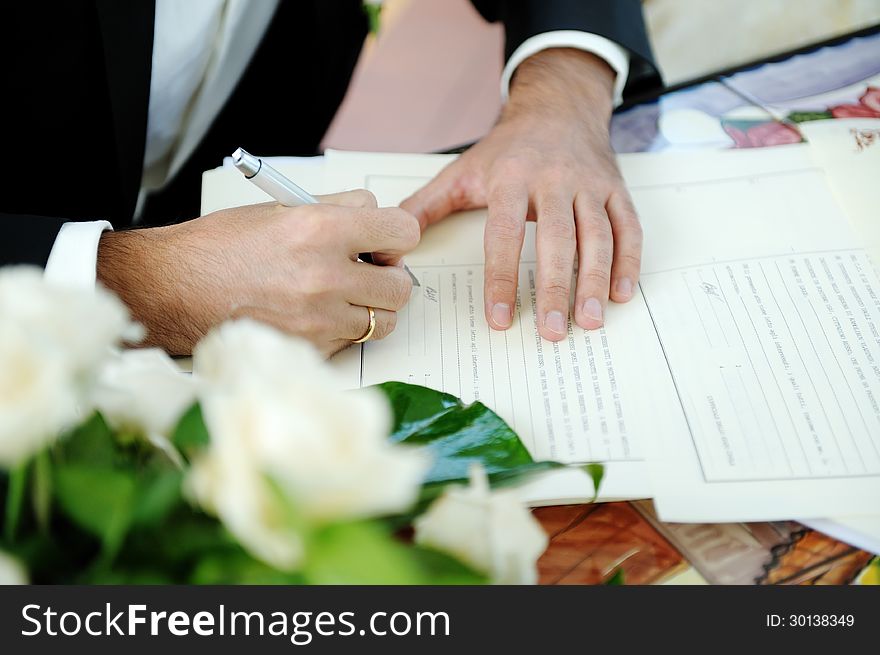 Groom signing marriage license or wedding contract. Groom signing marriage license or wedding contract