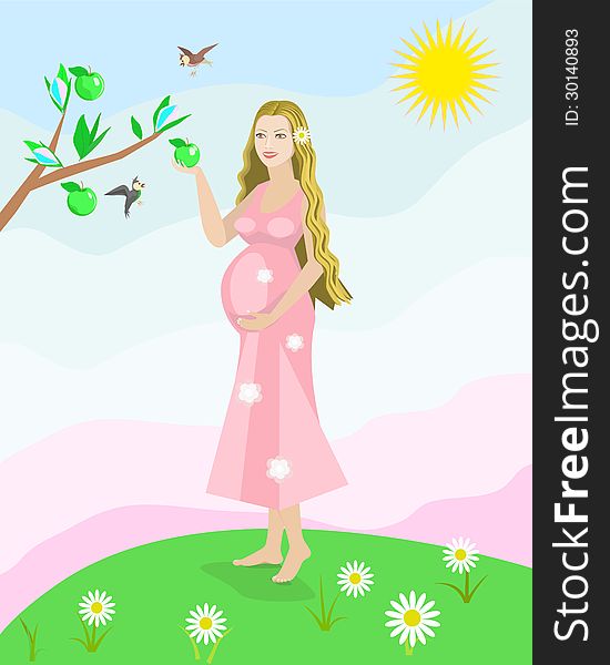 Pregnant woman standing in a meadow and keeps a green apple in her hand