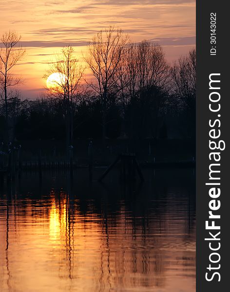 Late afternoon with orange sky and silhouetted treeline