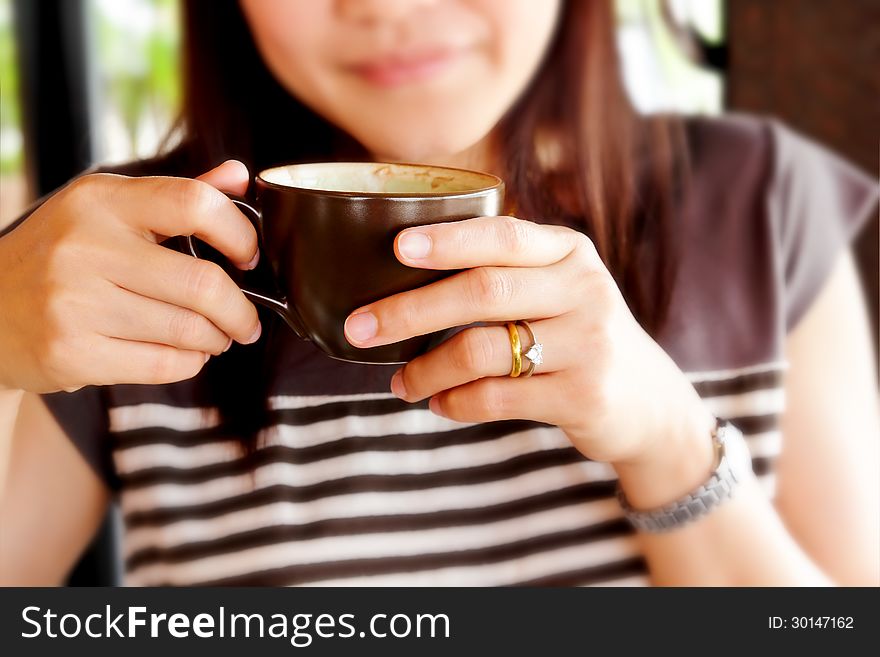 Woman drinking hot coffee at rest in the coffee shop. Woman drinking hot coffee at rest in the coffee shop