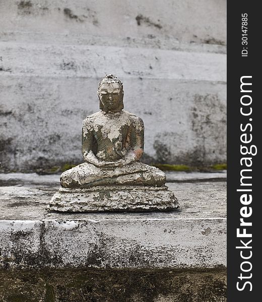 Ancient Buddha statue on white stone