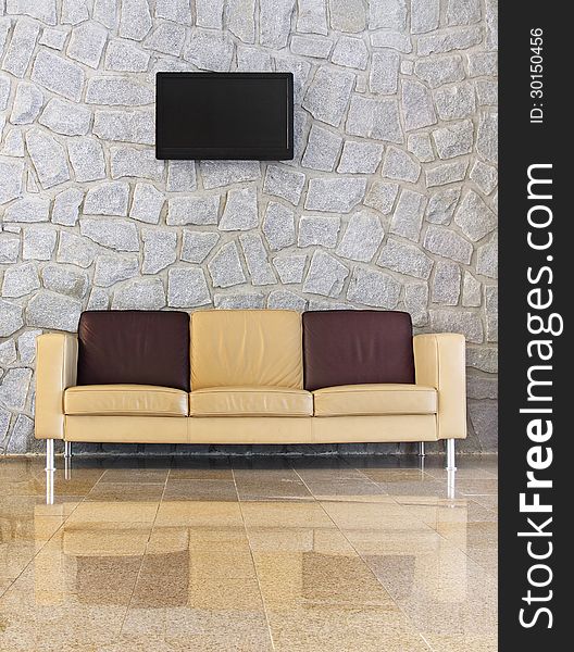 Leather sofa in front of the stone wall