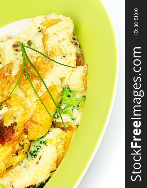 Delicious Omelet with Broccoli and Spring Onion on Green Plate closeup