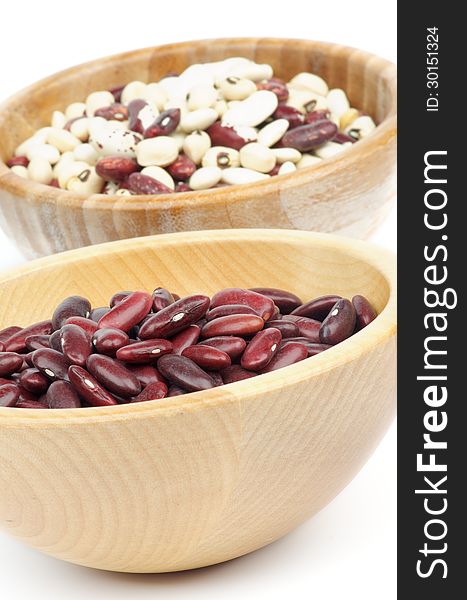 Two Wooden Bowls with Red, White and Variegated Bean closeup on white background. Two Wooden Bowls with Red, White and Variegated Bean closeup on white background