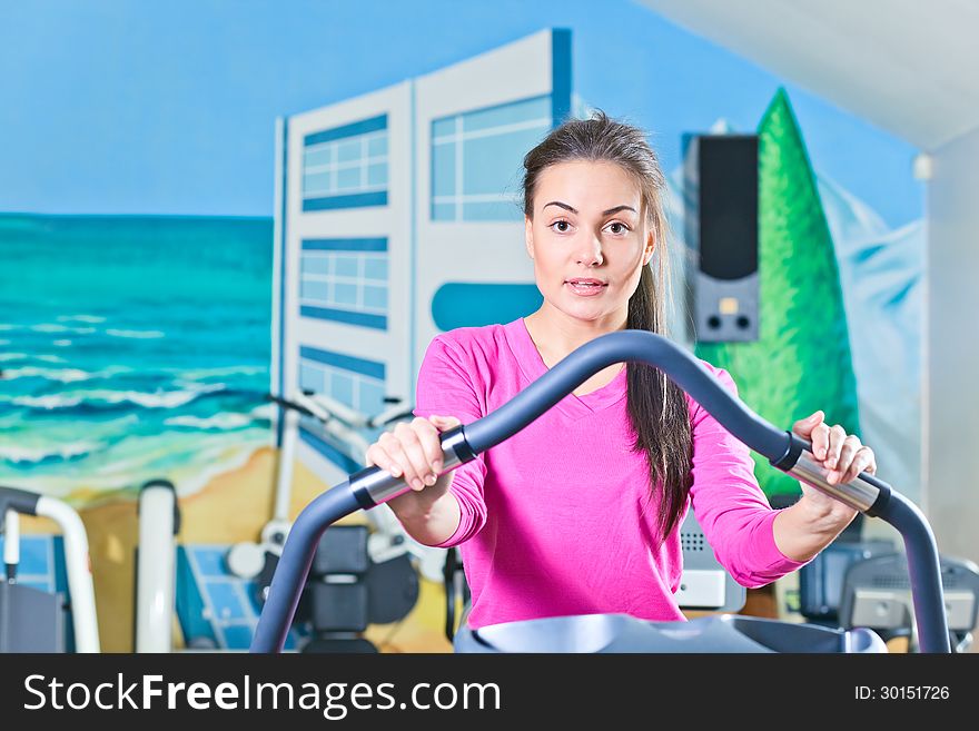 Young beautiful girl working out in a gym. Young beautiful girl working out in a gym