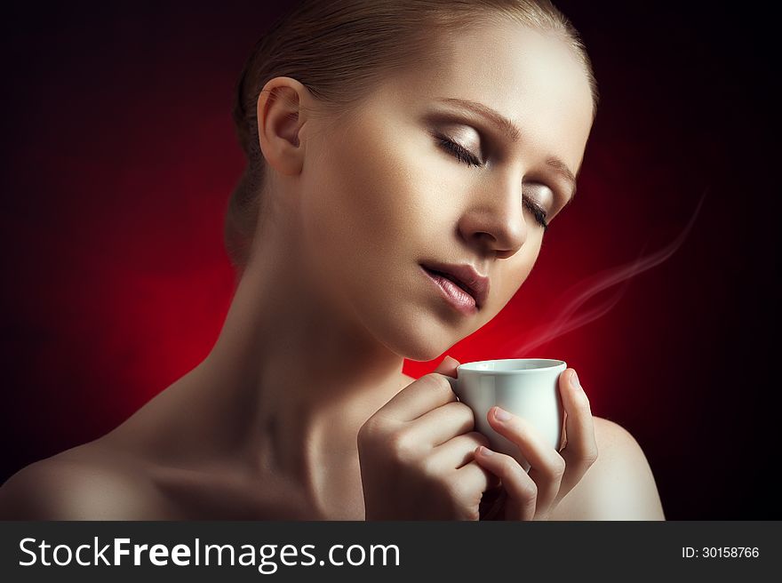 Portrait of woman enjoying a hot cup of coffee on a dark background. Portrait of woman enjoying a hot cup of coffee on a dark background