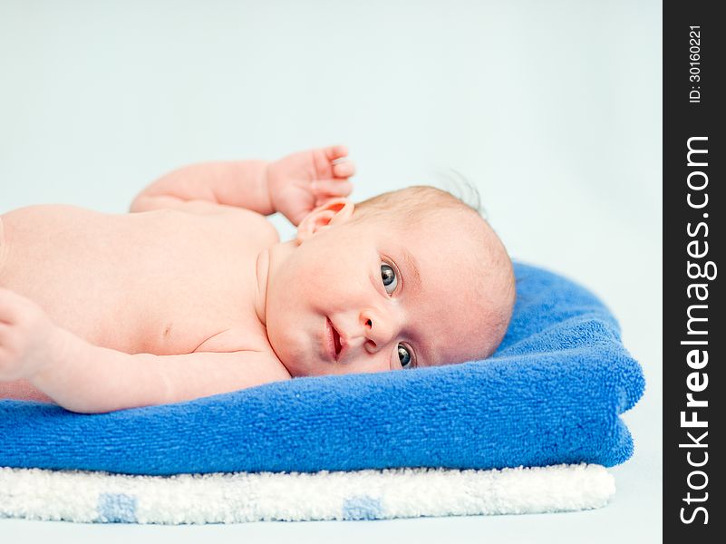 Cute Newborn Baby Lying On A Stack Of Towels