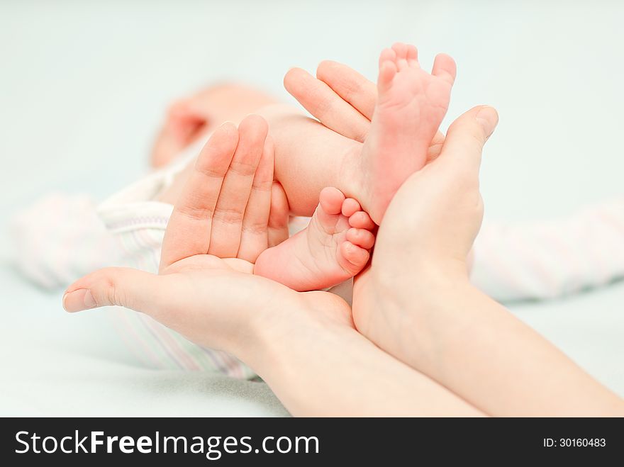 Little baby feet and hands of the mother. This image has attached release.