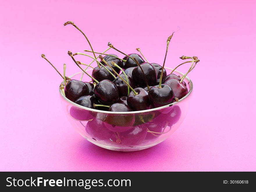 Fresh cherries bowl on pink background. Fresh cherries bowl on pink background.