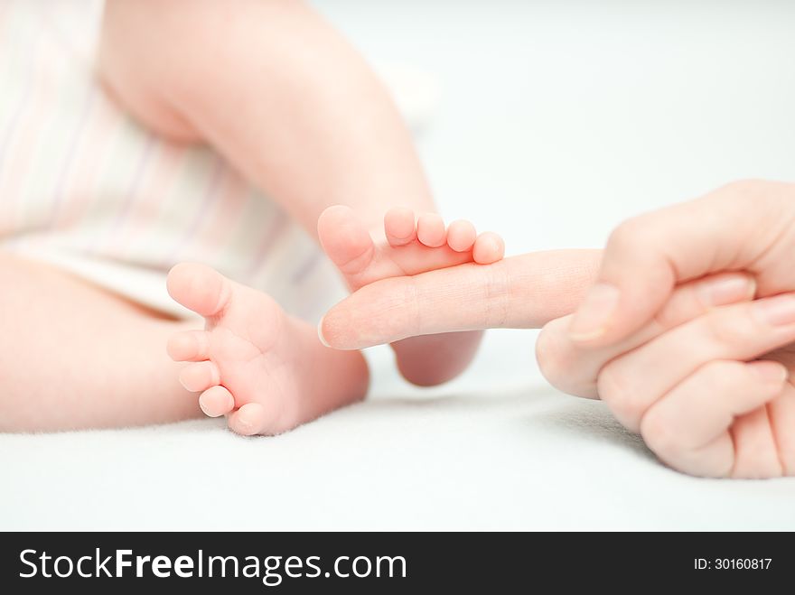 Little baby feet and hand of the mother. This image has attached release.