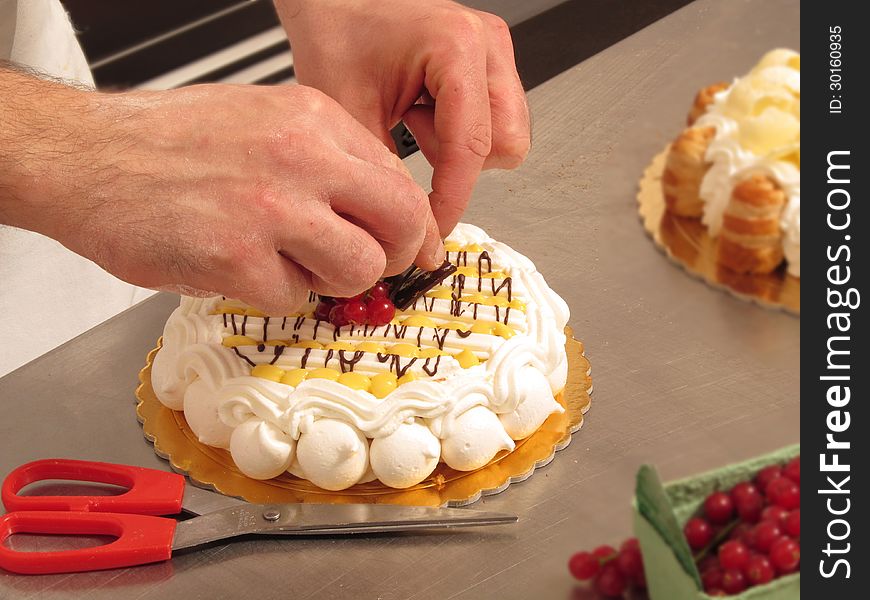 Chef hands preparing cream and chocolate cake. Chef hands preparing cream and chocolate cake.