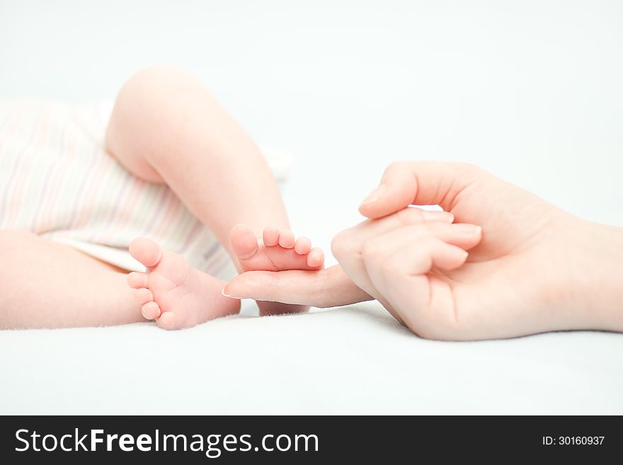 Little baby feet and hand of the mother. This image has attached release.