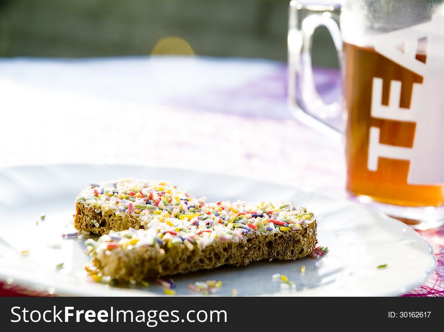 A detail of a picknick table with bread and sprinkles. A detail of a picknick table with bread and sprinkles.