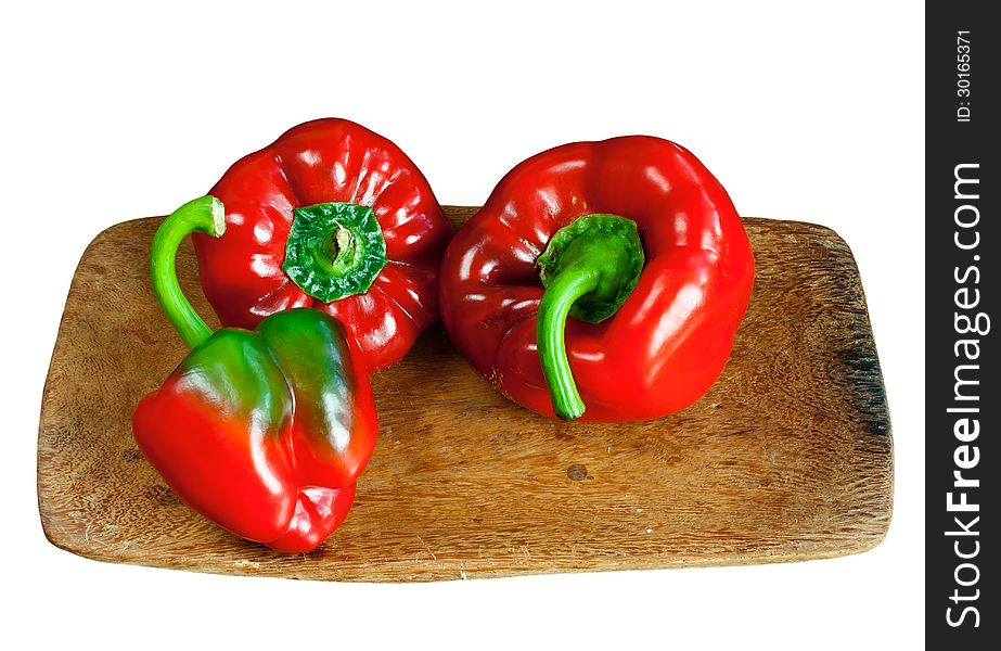 Red ripe sweet pepper on wooden board isolated over white. Red ripe sweet pepper on wooden board isolated over white