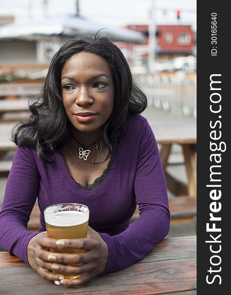 Young African American woman and a pint of pale ale. Young African American woman and a pint of pale ale.