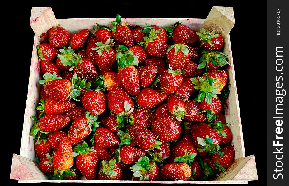 Strawberry in wooden box over black background. Strawberry in wooden box over black background