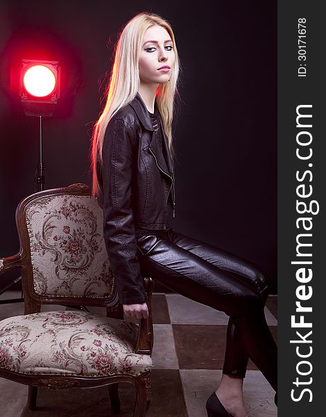 Girl in leather jacket with a red light behind