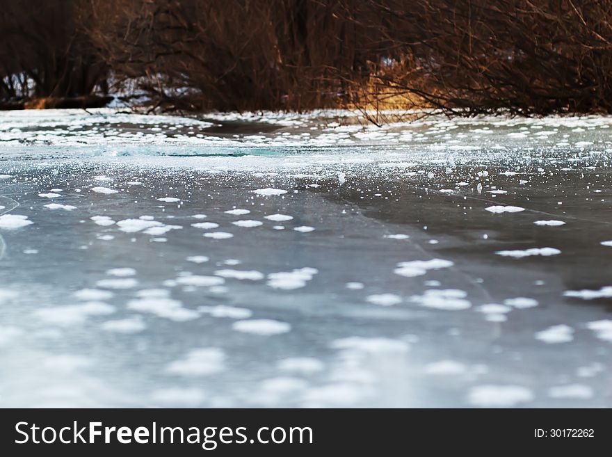 Frozen river with ice and sun reflection. Selective focus. Frozen river with ice and sun reflection. Selective focus.