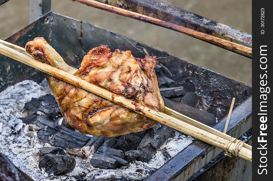 Close up of a chicken skewer in a barbecue at a food street market in Laos. Close up of a chicken skewer in a barbecue at a food street market in Laos.