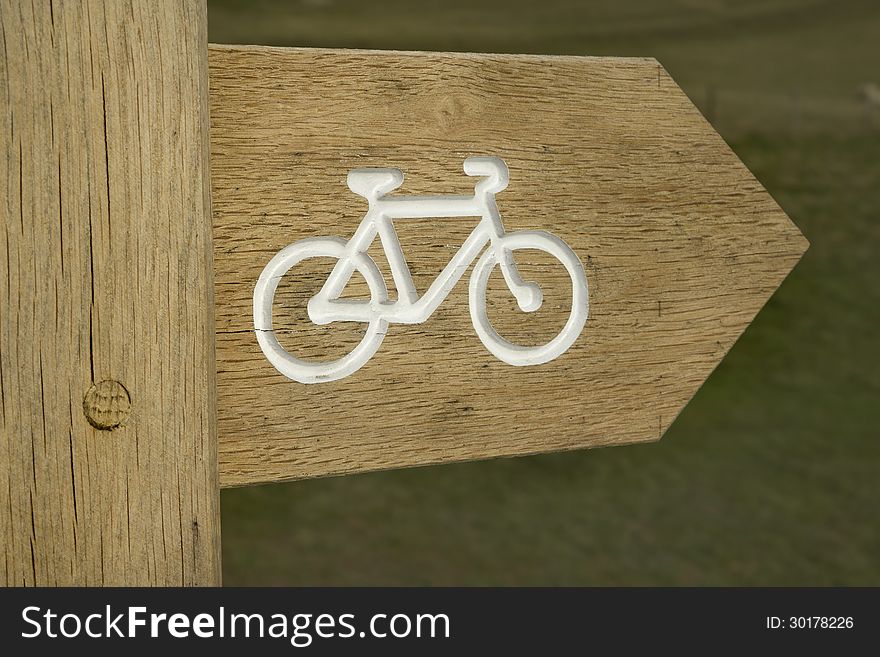 Wooden post showing cycle route in countryside. Wooden post showing cycle route in countryside