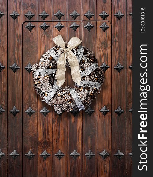 Traditional Christmas wreath in silver and gold on wooden door. Traditional Christmas wreath in silver and gold on wooden door