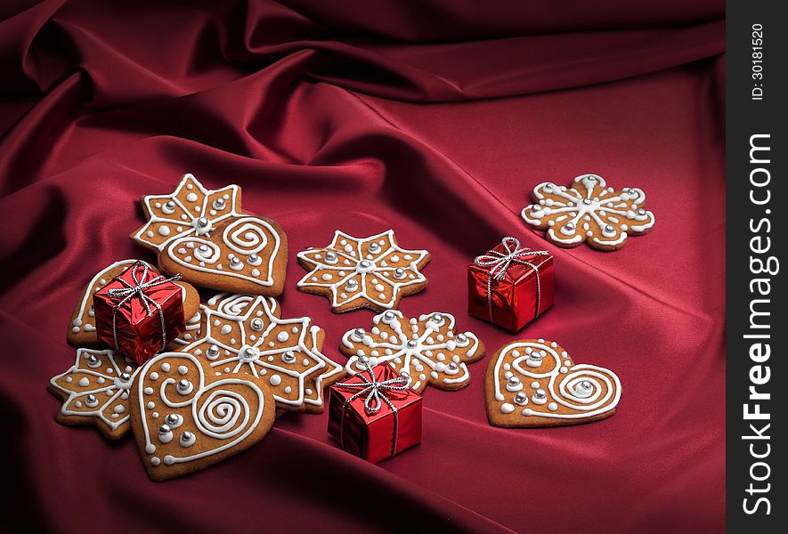 Decorated Christmas gingerbread cookies on red silky textile background. Decorated Christmas gingerbread cookies on red silky textile background