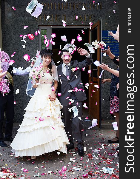 Happy newlyweds and flying petals after the registry office