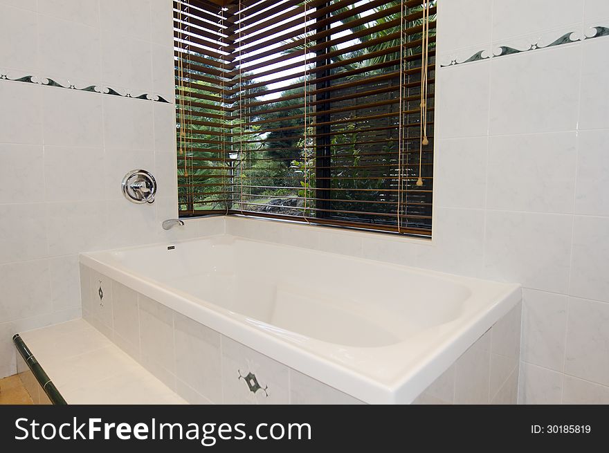 Modern bathroom with white tiles and a window.