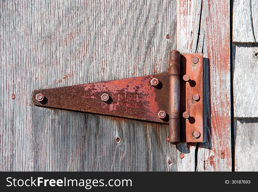 Rusty hinge on a wooden barn door. Rusty hinge on a wooden barn door