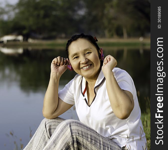 Beautiful asian woman listening music in headphones, outdoor portrait