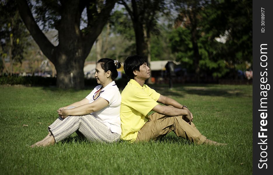 Portrait Of Beautiful Couple Sitting On Ground In Park