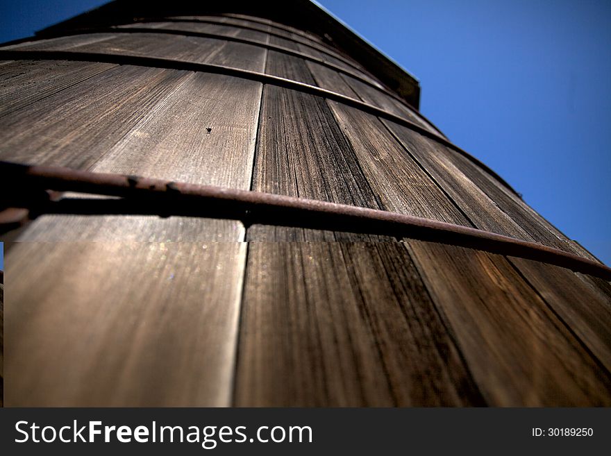 Old Wooden Water Tank shoot from a low perspective looking up with blue sky above.