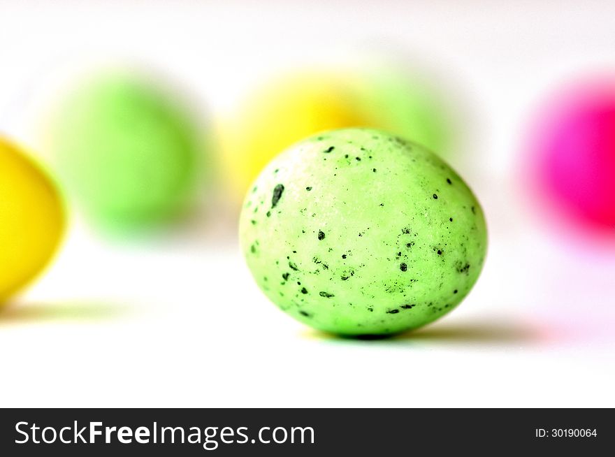 A green colored easter egg among several other blurred ones. A green colored easter egg among several other blurred ones