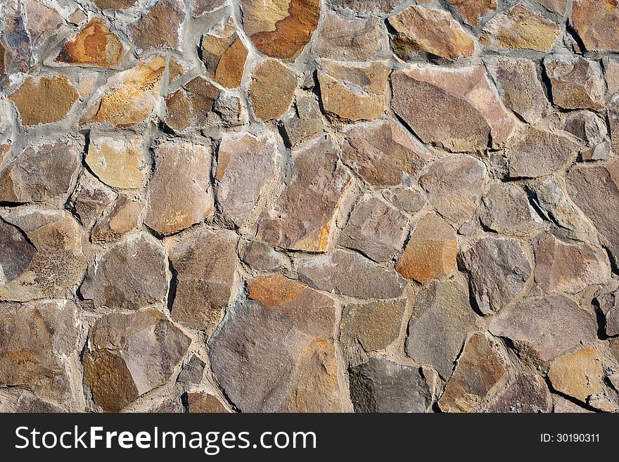 Irregular texture of the old yellow stone wall outside