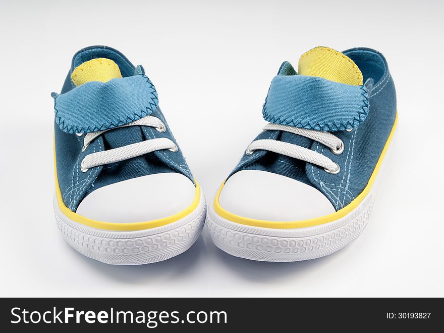 Nice baby's canvas shoes on white background