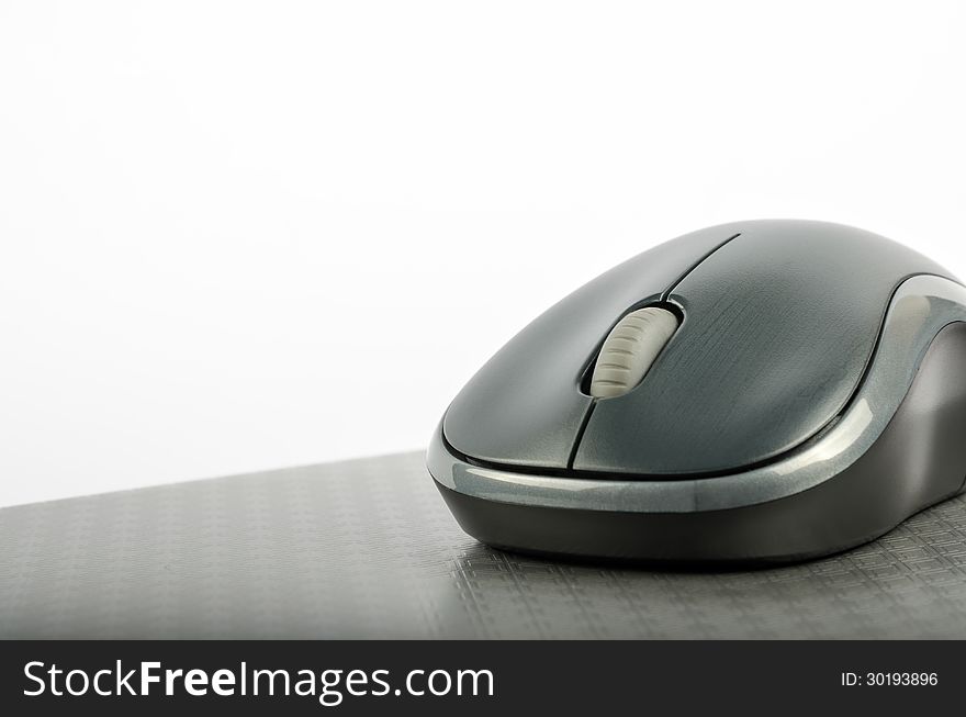 Wireless mouse on a metallic background. Wireless mouse on a metallic background