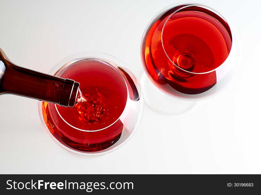 Two wineglasses filled with wine on white background