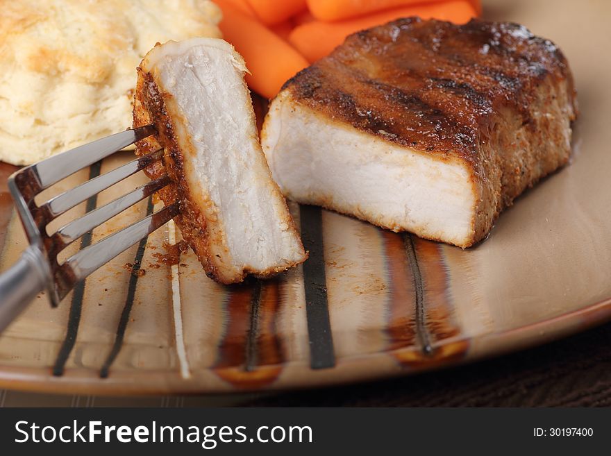 Grilled pork tenderloin meal with a piece on a fork