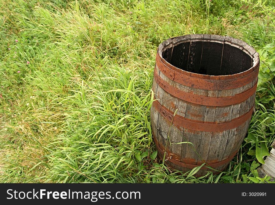 Old empty wooden barrel in green grass. Old empty wooden barrel in green grass.