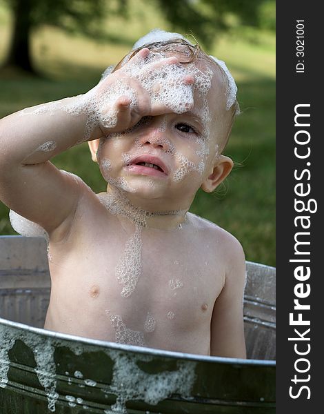 Image of cute toddler sitting in a tub outside. Image of cute toddler sitting in a tub outside