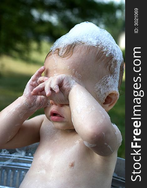 Image of cute toddler sitting in a tub outside. Image of cute toddler sitting in a tub outside