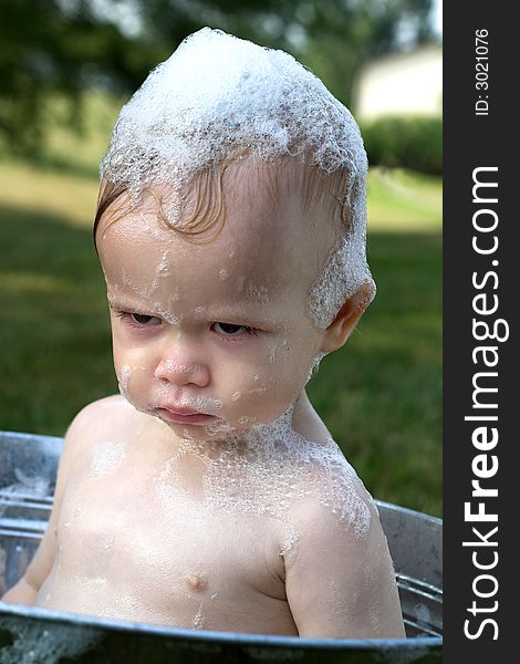 Image of cute toddler sitting in a tub outside. Image of cute toddler sitting in a tub outside