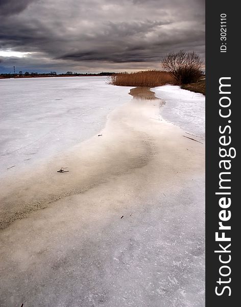 Storm clouds over a frozen lake