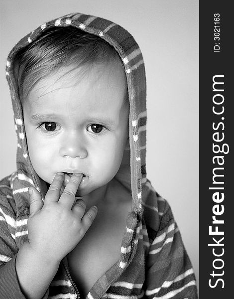 Black and white image of cute toddler wearing a hooded jacket