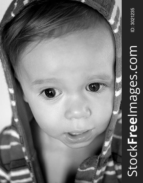 Black and white image of cute toddler wearing a hooded jacket