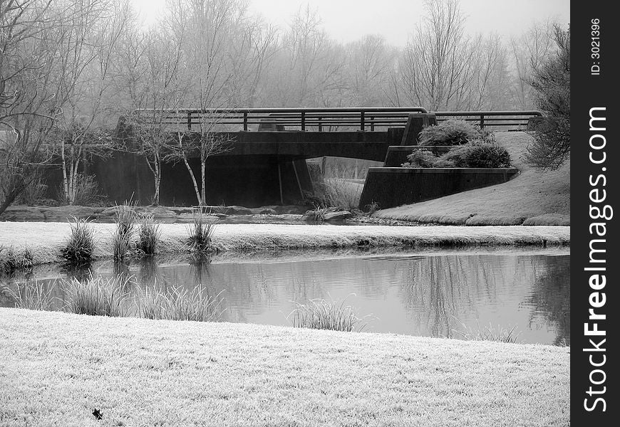 Bridge during a frosty morning surrounded by ponds. Bridge during a frosty morning surrounded by ponds.