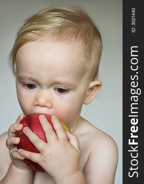 Image of cute toddler eating an apple. Image of cute toddler eating an apple