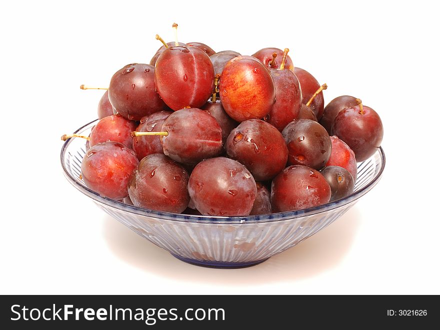 Glass bowl with plums isolated on white. Glass bowl with plums isolated on white