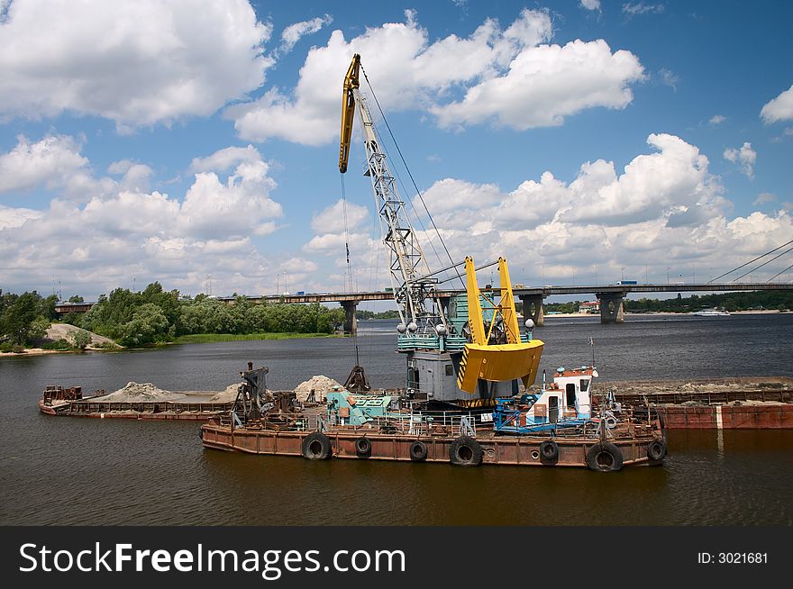 Hydraulic dredge on barge in the working river