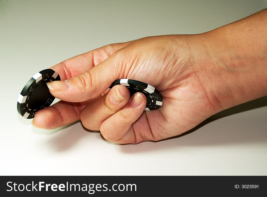 Hand holding two black poker chips. Hand holding two black poker chips